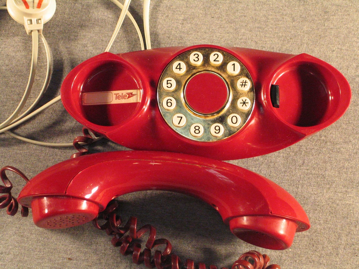 Båtforma haldar med tastatur. Står på ein liten oval stett. Rund gullforgyllt talskive med firkant- og stjernetast.Når røyret er lagt på har apparatet ein oval profil med opning i midten. Ledning med stikkontakt.
Sjå referansar/andre oppl.