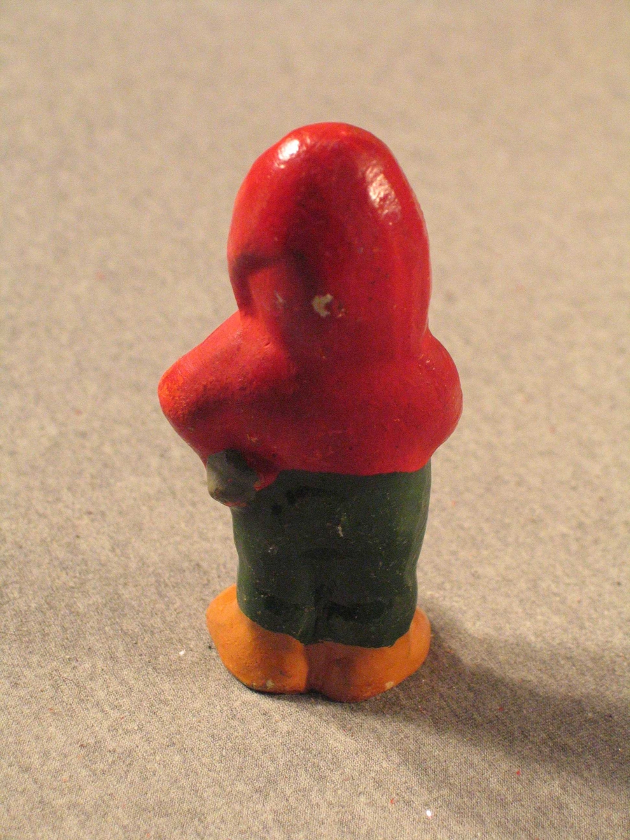 Nisse som står og røyker på ei fotsid pipe.