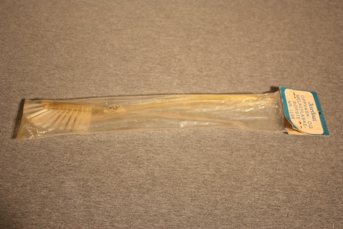 Smal kost med nylonbust og langt skaft i plast. Ligg i original plastpakning.