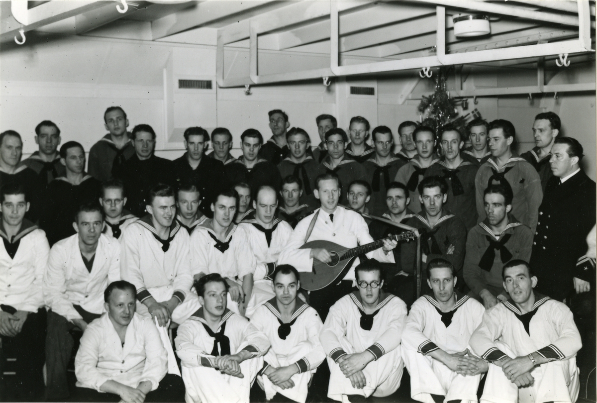 Besättningsbild från lasarettsfartyget Prins Carl  under julen 1942. I mitten sjukvårdskonstapel Leid spelande luta.