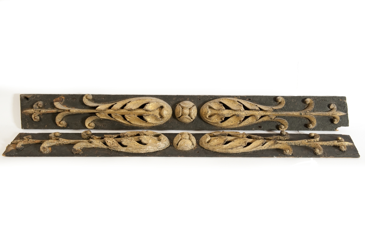 Pilaster till EUGENIES akterspegel. Skulpterade gulmålade blommor på underliggande förgyllning, monterade på plan av svartmålat trä.