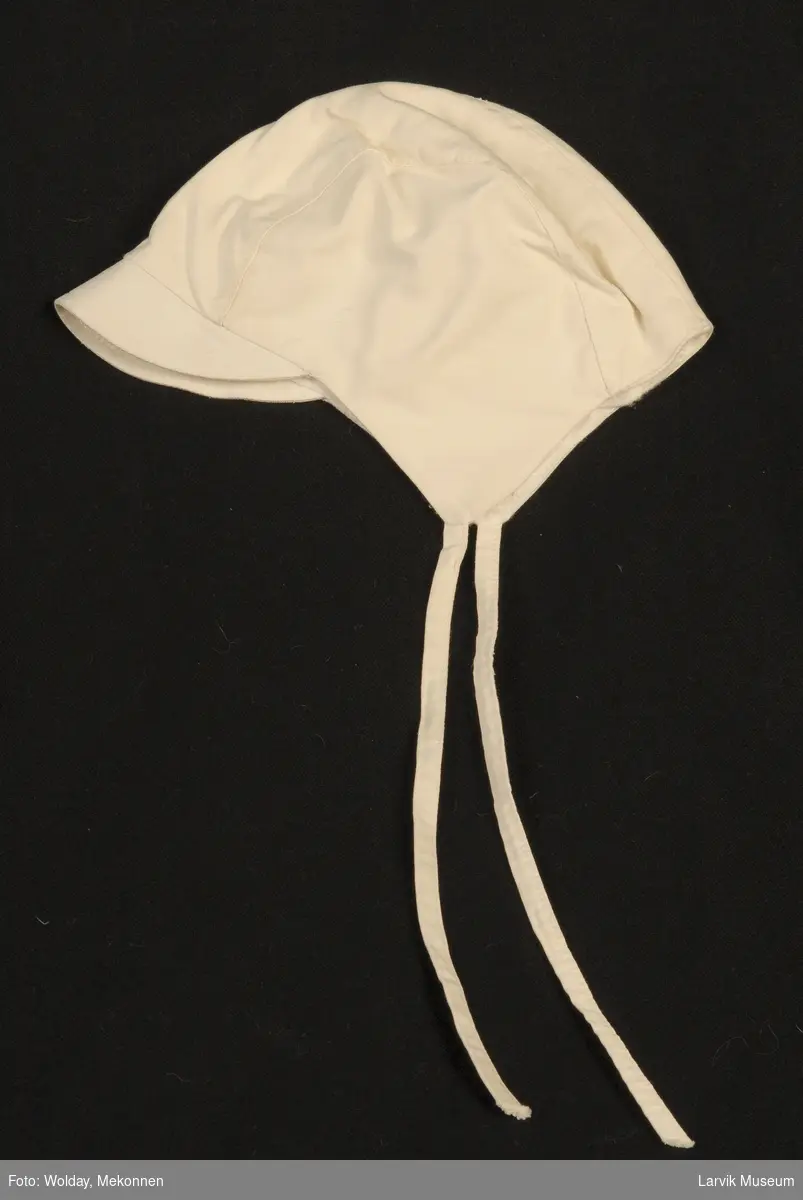 Form: skyggelue, ørestykke med knytebånd
