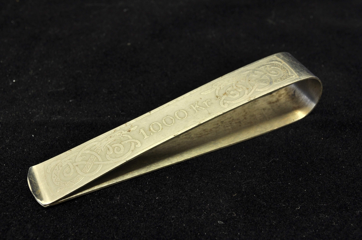 Beløpet "1.000 Kr." på den ene siden. Buktende drageskikkelser til høyre og venstre for beløp, og på den andre siden.