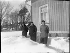 Ester, Linnea o. Lilly Karlsson bland snödrivor vid verandan.