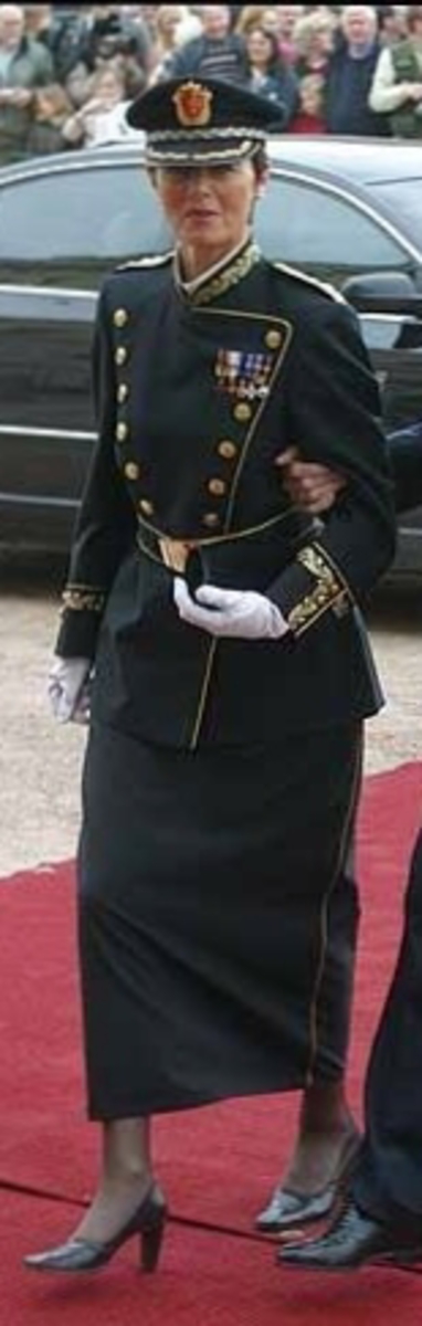 Foret, sort jakke med gullbrodert eikeløv med nøtter på krave og på ermer. 14 gullforgylte knapper i front, to på hvert erme og seks ved splitten bak. Gullkant langs hele fronten, på kraven på ermene og ved splitten. Epåletter i flettet gull med fire stjerner og eikeløv (politidirektør). Hvit løssnipp festet med borrelås.

Langt, sort skjørt med gullrender i sidene og glidlås bak.

Sort politilue med luemerke i gull og rødt og eikeløvsbroderier i sort og gull. To forgylte knapper holder luesnoren på plass.

Sort stoffbelte med gullkant innvevd mønster (eikeblad og sikksakkbord) Rektangulær beltespenne i gullforgylt metall med riksvåpen. Beltets lengde kan reguleres med borrelås på innsiden, og er nå 90 cm langt medregnet spennen.

Det hører til hvite hansker, men disse mangler.