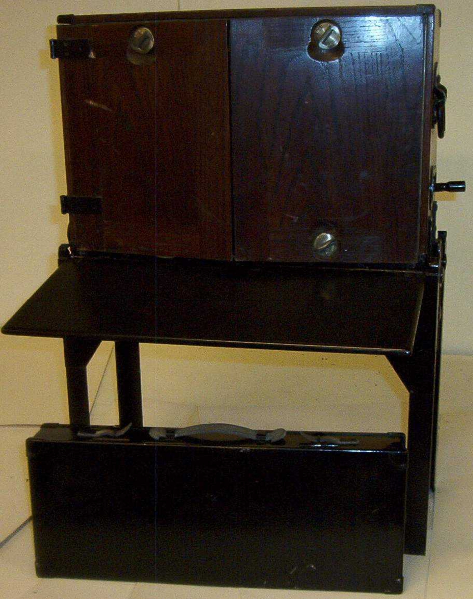 Telefonsentral (feltveksler) av eldre type med ledninger og plugger i grønn transportkasse på fire bein.