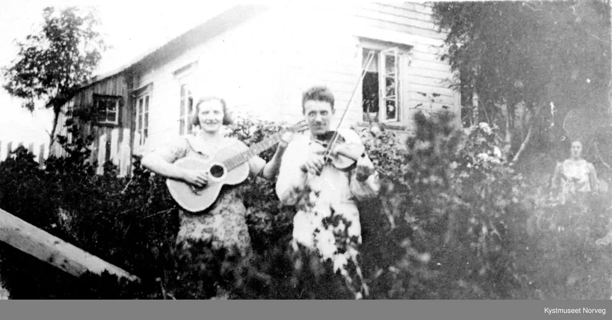 Ukjente ungdommer spiller gitar og fele i en hage, Flatanger