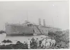 Foto visande post-pch passagerarångfartyget CHINA av London, som onsdagen den 25 mars 1898 ränt upp på klipporna i Röda Havet vid Perim och bärgades av Neptunbolaget i samarbete med Norddeutsher Bergungs-Verein. Fartyget, som tillhörde Peninsular& Oriental Steam Navigation på resa från Sidney till London, när hon med 16 knops fart gick rakt på Azalearevet vid Perim. Vid den våldsamma påseglingen mot reven hade stora block lossnat och hopat sig vid fartygssidorna så att fartyget formligen låg i en grav. Fartyget hade flott - tagits den 16/9 1898.