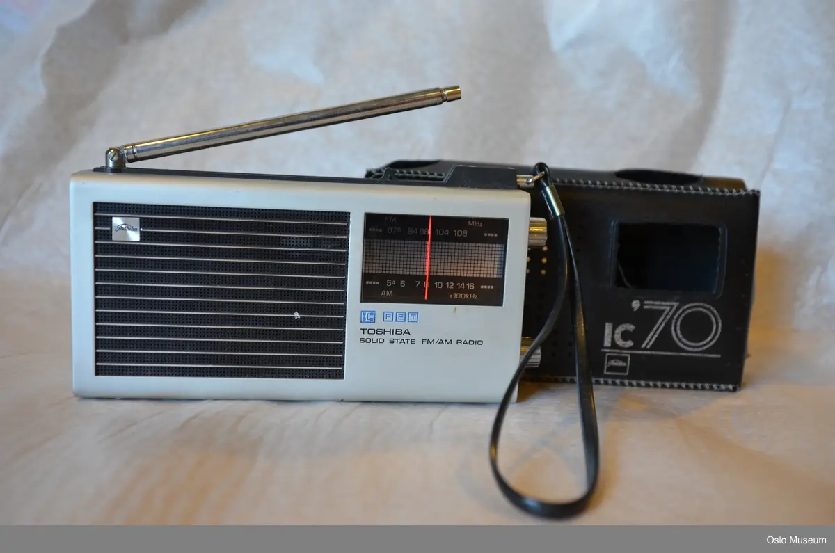 Lommeradio i stål og plast med uttrekkbar antenne. Etui i sort skai med hank.