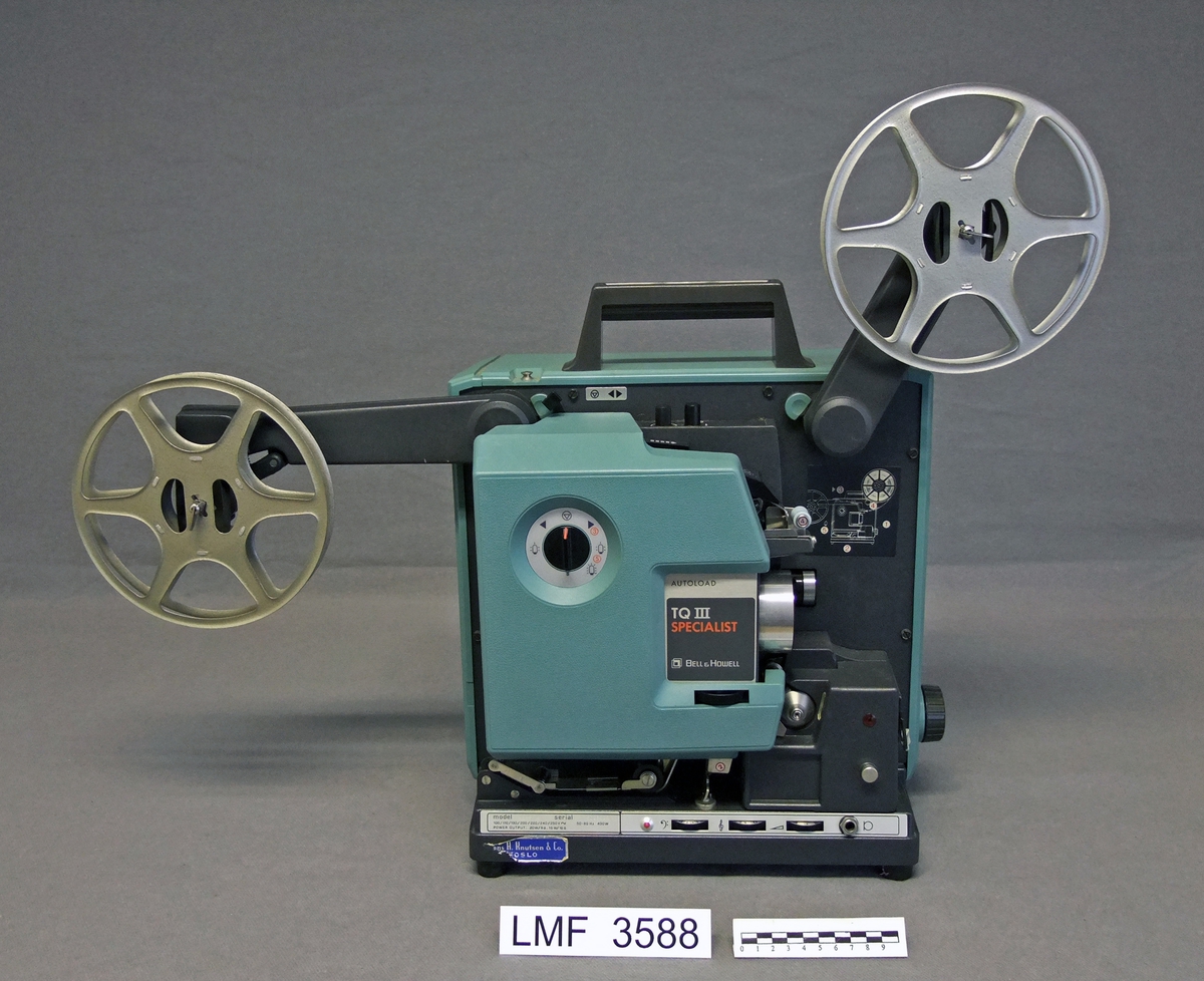 Amerikansk filmframviser beregnet på 16 mm film.
Avtagbar lydenhet som ble festet på framviseren før transport.
5 tilhørende, tomme filmruller i 4 ulike størrelser.

Produsent og tittel på selve framviseren :
     Bell & Howell - TQIII Specialist Model 1695

Produsent og tittel på lydenheten (avtagbar) :
     Bell & Howell - Filmosound