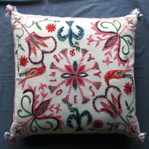 Broderad kudde i Skånskt yllebroderi. Vit botten och grön baksida. Duskor i hörnen. Stjärna med kvastar i mitten. Monogram och årtal mellan kvastarna, OES AAD 1841. I två hörn kronor, i de andra två hörnen liljor. Fåglar på sidorna.Två kuddar syddes upp efter orginalet, en till föreningen och en till Hanna Rosendahl  som sedan skänkte orginalet till Muséet i Kristianstad. Föreningens kudde var med på utställningen på Liljevalchs 1998, Slöjden är här Slöjden är härlig.