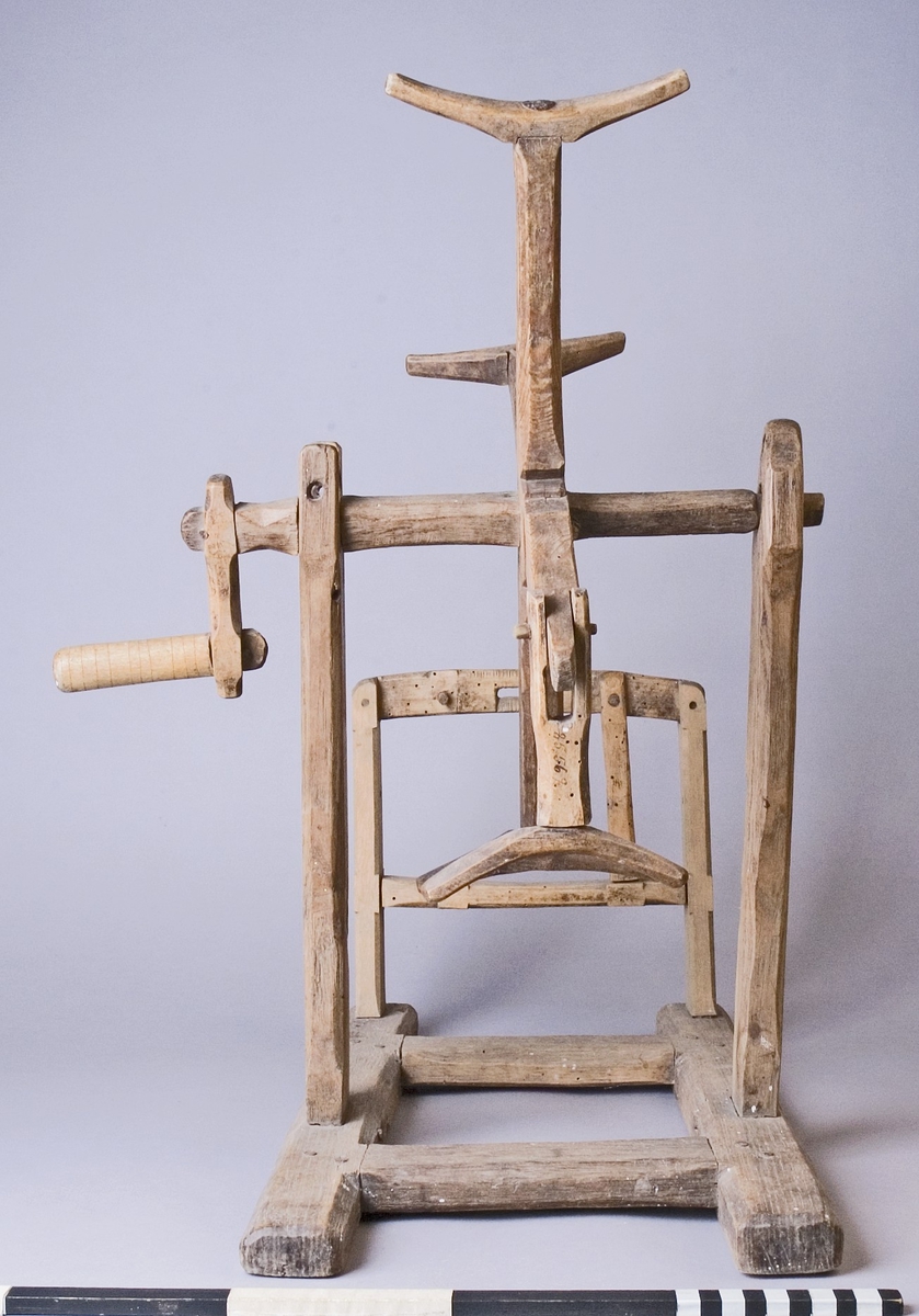 Härvel av furu, ek och björk. Bottenplatta av H-formad ram med två ståndare som bär upp härvelhjulet och två ståndare för hållare till garnspole. Härvelhjulet med fyra armar, varav ett är ledat. Hjulets axel med svarvad vev. Tappad med träplugg.