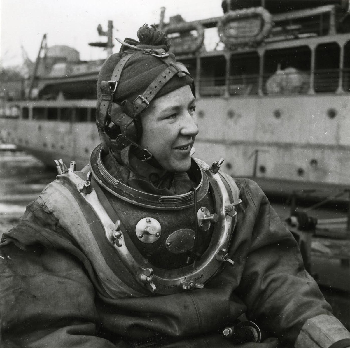 Dykarbete på ubåten Sjöormen 1949.
Tungdykare kollar hjälmen på däck. Fartyget förtöjt vid Skeppsholmen.