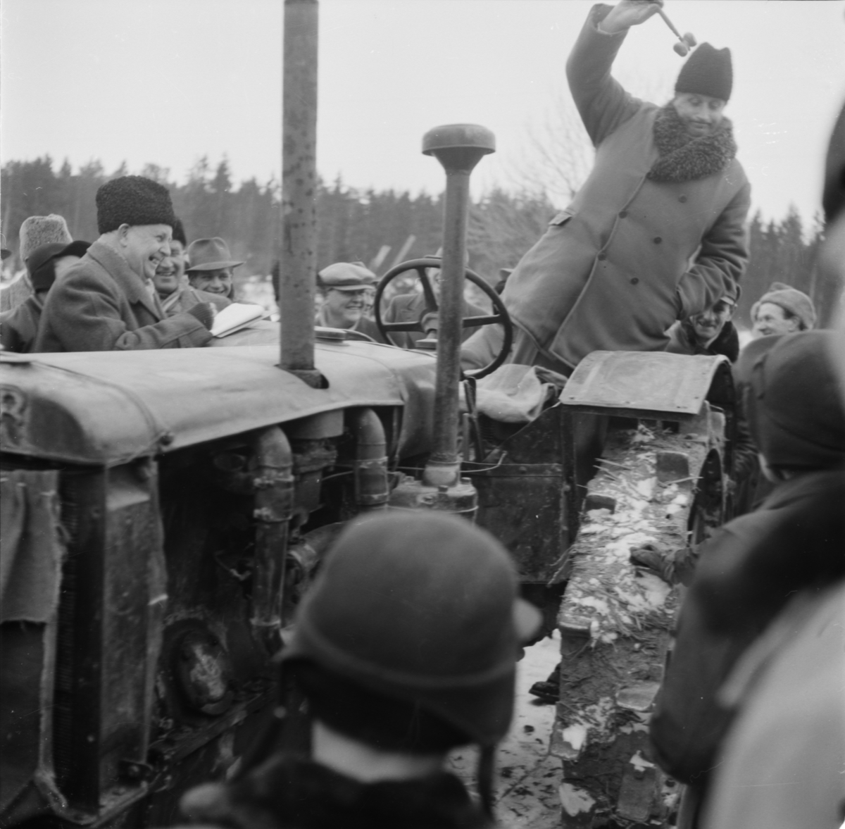 Auktion med auktionsutropare Oskar Målman, från Litselås, Tillinge och skrivare (till vänster i pälsmössa) Ernst Andersson, sannolikt vid Holms prästgård, Holms socken, Uppland 1955