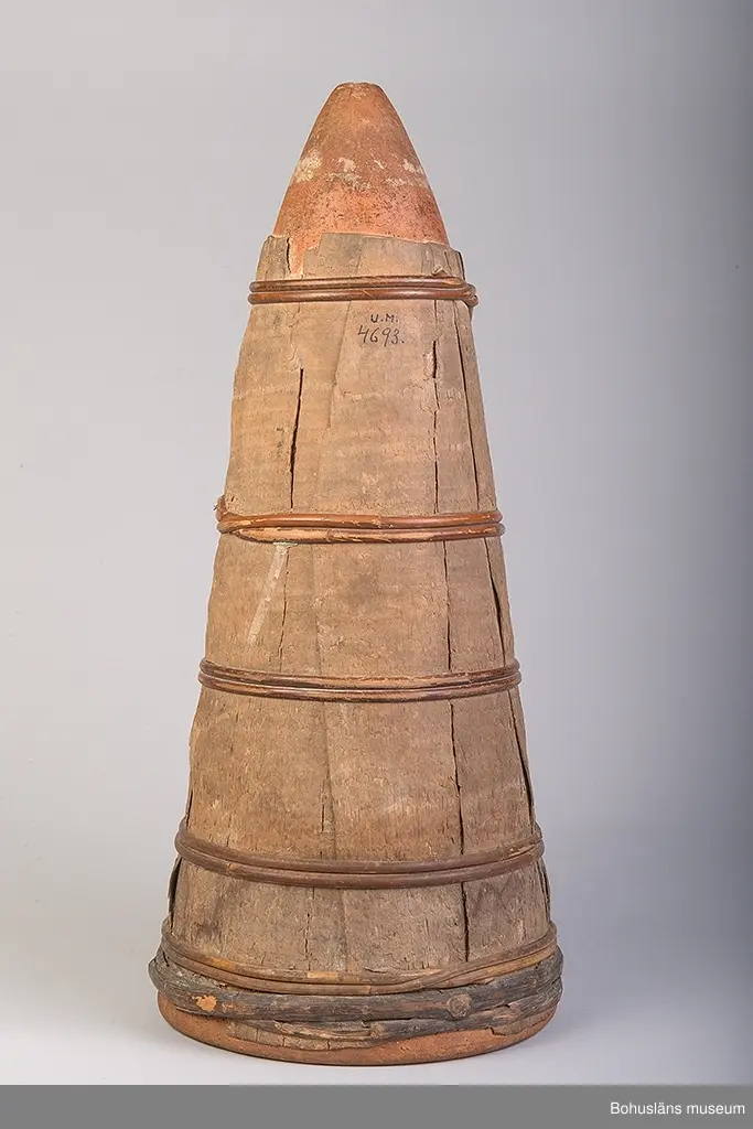 Ur handskrivna katalogen 1957-1958:
Sockertoppsform
H. 55 cm; största D. 25 cm; rött lergods, spånklädd. Hel.
Rester av socker täcker delar av formens insida.