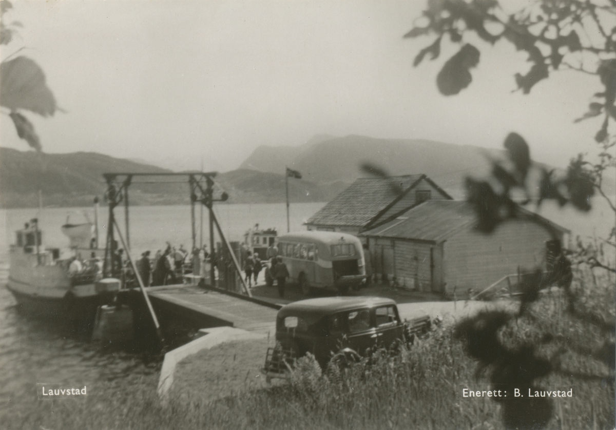 Motiv fra fergeleiet på Lauvstad mot Voldsfjorden. Flere passasjerer står ved og i fergen. En rutevog og bil står ved kaien.