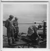 Professor Leonard Axel Jägerskiöld (andre från vänster), dr Hugo? Oldevig och jägare Carl Johansson i Tjolöholm. Samlade vid en brygga. Hink på marken.