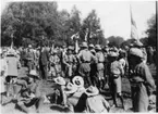 Scouter (män, pojkar) på sommarting i Göteborg, närbild från gräsmattan. (hade samlat ett tusental från hela Sverige enligt bildtext). Iklädda scarf och scoutskjorta, hatt. Samlade på öppen gräsmark. Se även ev. fotonr. 5023.