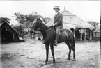 'Diverse fotografier från bl.a. dåvarande Nordrhodesia, nu Zambia, tagna av Konsul Magnus Leijer. ::  :: 1 st man till häst fotograferad snett framifrån. I bakgrunden är enklare byggnader och tält samt barn synliga.'