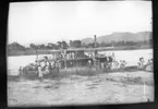 'Diverse fotografier från bl.a. dåvarande Nordrhodesia, nu Zambia, tagna av Konsul Magnus Leijer. ::  :: Ett hjulfartyg liggande vid en strand, på stranden står ett flertal människor, likså på fartyget.'