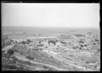 'Vy över del av stad med hus och byggnader, vy ut över hamnen och havet. Båtar i hamnen. ::  :: Ingår i serie med fotonr. 5283:1-19. Se även fotonr. 5269-5292 med bilder från Stuxbergs resa till Kaukasien.'