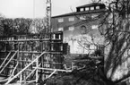 'Tillbyggnaden av Göteborgs Naturhistoriska Museum mars-april 1979. Södra ytterväggen Göteborgs Naturhistoriska Museum och byggarbetsplatsen. Träplank uppsatt. ::  :: Ingår i serie med fotonr. 5527:69-216.'