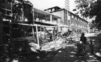 'Tillbyggnaden av Göteborgs Naturhistoriska Museum juni 1979. Östra och södra ytterväggen Göteborgs Naturhistoriska Museum. Tillbyggnaden och en silo. Kvinna med barnvagn med barn samt en liten pojke som håller i handen. ::  :: Ingår i serie med fotonr. 5527:69-216.'