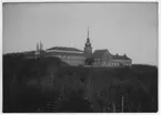 Naturhistoriska Museet i Slottsskogen sett från sydöst. Utsiktstornet synligt i bakgrunden. Kyrkan tillhörande ålderdomshemmet bakom museét synlig.