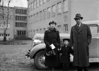 Kvinna, man och barn utanför skolbyggnad, Uppsala 1936