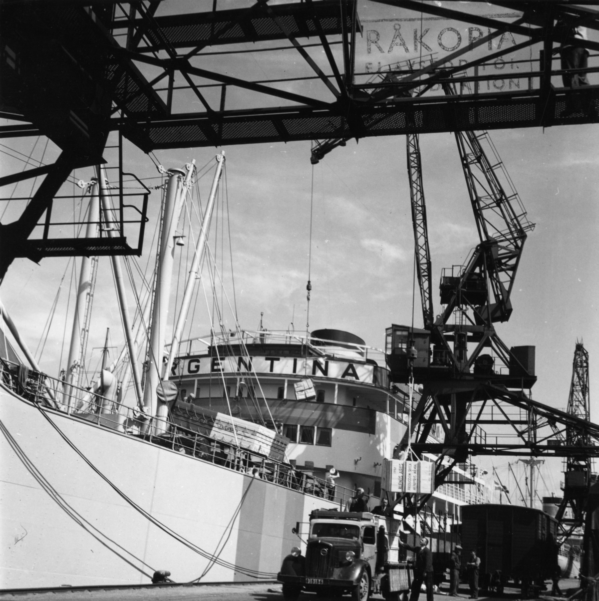 Lastning vid Frihamnspiren i Göteborg. 

Fartyget på bilden är M/S Argentina II. Argentina byggdes på Götaverken 1943. Hon sjösattes 28 augusti 1942, samt gick på provtur och levererades sedan den 27 januari 1943. Gjorde under återstoden av kriget ett flertal lejdresor till Argentina och Brasilien. Svenska exportvaror ner, samt en rad livsnödvändiga produkter hem bl.a. spannmål. Tidvis mellan lejdresorna när hon väntade på utväxling låg hon upplagd i Göteborg. Befälhavare när hon gick ut på första resan var K. Andreasson samt Maskinchef var J. Elowsson. Denna fartygsserie som byggdes för Johnson (Nordstjernan) mellan 1935 och 1948 bestod av 21 fartyg. Sjutton av dom var byggda på Götaverken samt fyra av dom var utlagda för byggnation på Kockums. Det var systerfartyg alltså byggda på samma ritningar, men naturligtvis skedde en del smärre förändringar genom åren. Men rent utseendemässigt är det väldigt svårt för en amatör att se skillnad på fartygen. Men en sak som skiljer om man vet om det är placering och antal fönster (ventiler) på förkant promenaddäck, alltså däck nummer två. På Argentina I, den som byggdes 1935 och minsprängdes 1942, fanns det på förkanten här 16 fönster (ventiler), de gick ända ut till rundningen på sidan av bygget. Medan däremot Argentina II (den på bilden) som byggdes 1943 endast hade 12 fönster (ventiler) på förkant detta däck, och de gick inte heller hela vägen ut till rundningen (sidan). 

När det gäller M/S Argentina I, detta fartygsnamne, kommer här en redogörelse för dess öde. Den sista resan anträdes 3 april 1942. Destinationen för resan var Buenos Aires i Argentina, I lasten ingick bland annat papper från AB Papyrus.

M/S Argentina I gick i lejdetrafik under Andra Världskriget och resan till Buenos Aires gjordes i sällskap med bolagsfartyget Annie Johnson. Från Buenos Aires gick man senare vidare till Santos i Brasilien.

15 juli 1942 lämnade man Santos i följe med Svenska Amerika Mexiko Liniens M/S Uddeholm.  Den 6 juli körde de två fartygen på en tysk minspärr 30 sjömil sydväst om Kristiansand. Först gick Uddeholm på. Där klarade sig hela besättningen. Därefter var det M/S Argentinas tur. Detta fartyg sjönk på två minuter. Fyra man omkom varav två ur besättningen, en kontrollofficer och en passagerare.