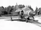 Kamouflerat provflygplan 37 Viggen tillhörande Försökscentralen, märkt nr 09 på marken. Rangeringsstång påkopplad.