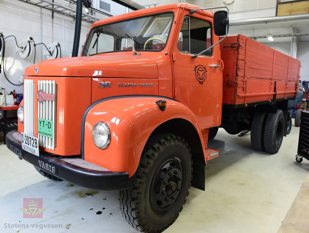 Lastebil på 6 hjul, (to akslet) med bakhjuls drift. Akselavstand 4,2 meter.  I hovedsak oransje. Motoren er en turbomatet 4-sylindret dieselmotor av typen Scania-Vabis DS5, den yter 120 hestekrefter og har et sylindervolum på 5193 kubikkcentimeter. Girkassen er en manuell 5-trinns synkronisert utgave, høy- og lavgir i bakakslingen (two-speed) gir tilsammen 10 gir pluss revers. Bremsene er drevet av trykkluft. Bilen har lasteplan med karmer og et ekstra sett karmer på toppen. Bilen har 3-veis hydraulisk tipp fra Thanstrøm i Halden. Svart interiør, lakkert grå innvendig. Egenvekten er ca. 5,1 tonn, lasteevne ca. 5,825 tonn. Totalvekt 11 tonn.
Farge: paprika rød.