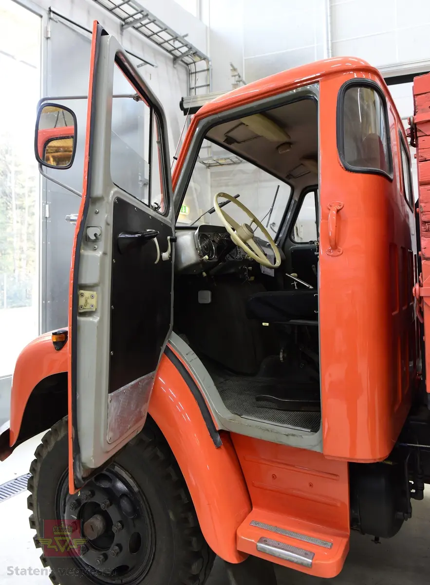 Lastebil på 6 hjul, (to akslet) med bakhjuls drift. Akselavstand 4,2 meter.  I hovedsak oransje. Motoren er en turbomatet 4-sylindret dieselmotor av typen Scania-Vabis DS5, den yter 120 hestekrefter og har et sylindervolum på 5193 kubikkcentimeter. Girkassen er en manuell 5-trinns synkronisert utgave, høy- og lavgir i bakakslingen (two-speed) gir tilsammen 10 gir pluss revers. Bremsene er drevet av trykkluft. Bilen har lasteplan med karmer og et ekstra sett karmer på toppen. Bilen har 3-veis hydraulisk tipp fra Thanstrøm i Halden. Svart interiør, lakkert grå innvendig. Egenvekten er ca. 5,1 tonn, lasteevne ca. 5,825 tonn. Totalvekt 11 tonn.
Farge: paprika rød.
