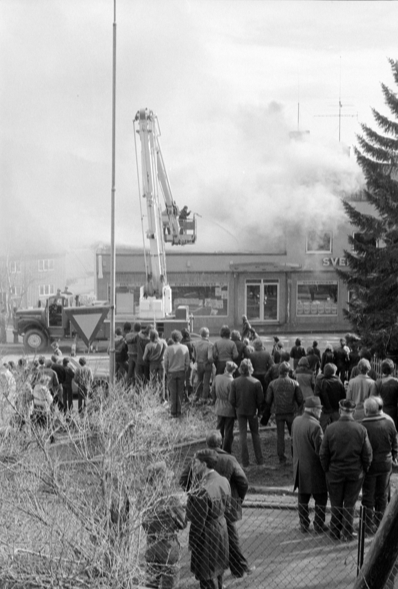 Folkemengde står og ser på at brannvesenet arbeider med slukking av brann på Seljestad.