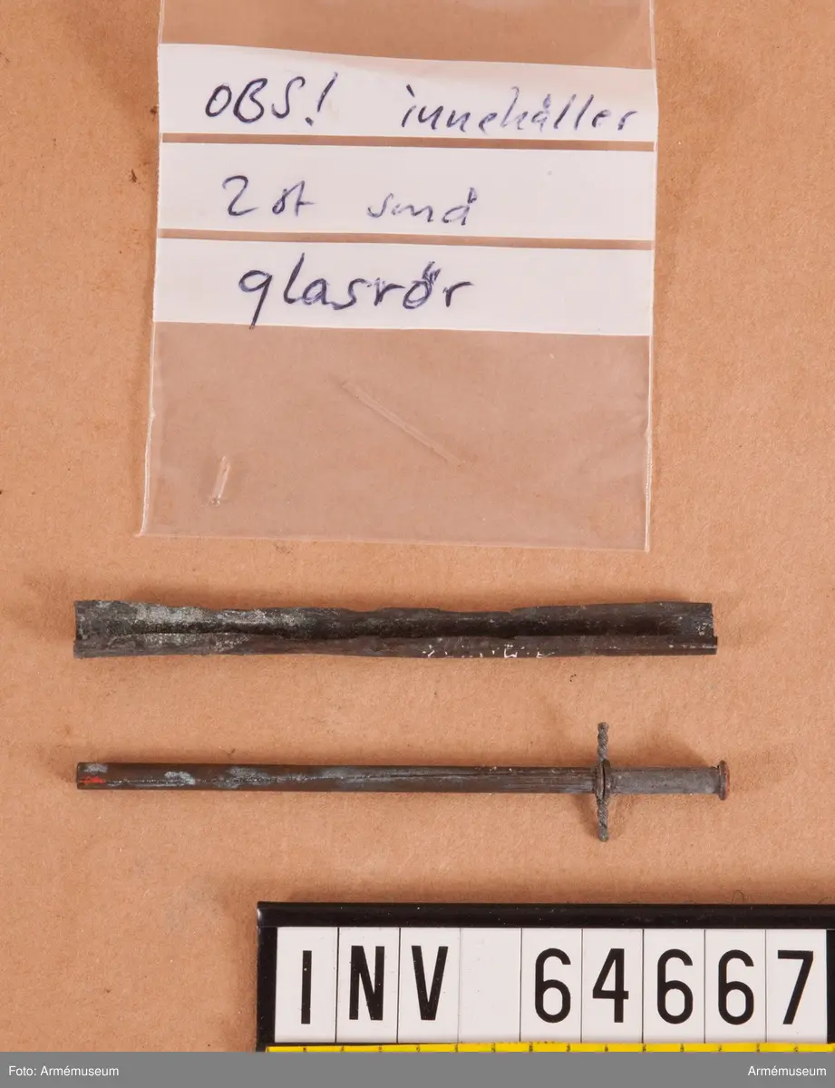 Grupp F II.
Antändningsrör. Callerströms invention 1829-30. Tändningen skedde genom att medelst en dragkrok avbryta rörets övre del, varvid där i ett glasrör förvarad svavelsyra utföll å klorsyrat kali, då explosion inträffade. Antogs vid fältartilleriet 1830.