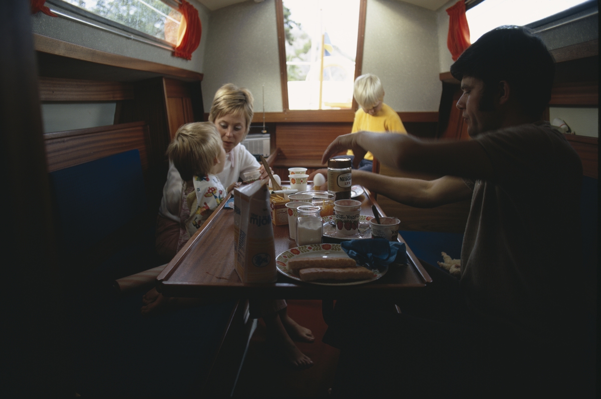 Interiör, ruff i Albin Vega. En familj äter frukost. Marknadsföringbild.