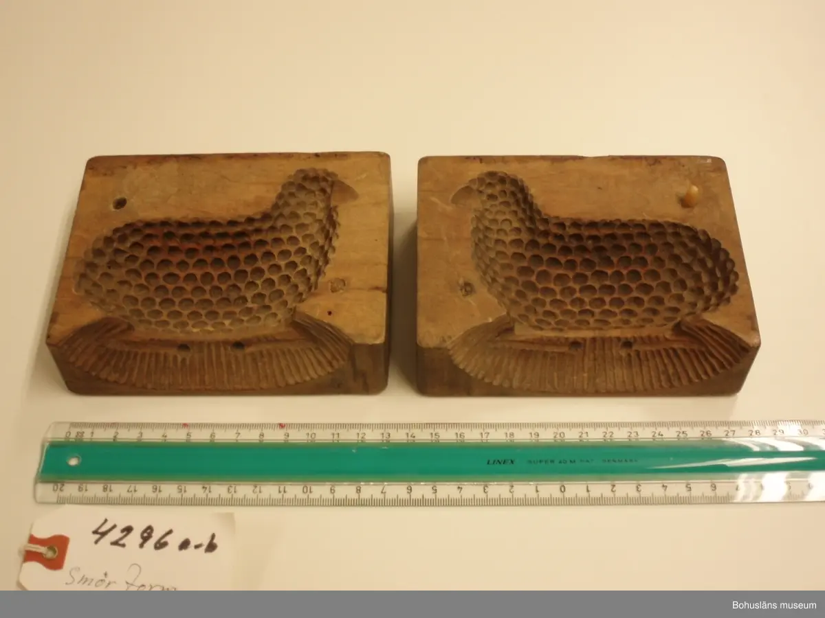 Tvådelad smörform som formar smöret till ett liggande lamm.

Ur handskrivna katalogen 1957-1958:
Smörformare
I 2 delar, a-b, mått (hopsatt)13,5 x 10,3 x 7,8 cm, av trä, omålat; form till höna el. dyl. Hel.