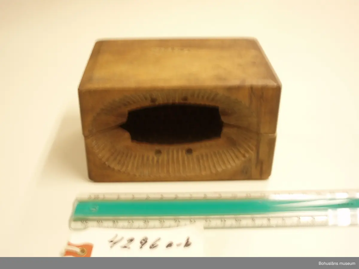 Tvådelad smörform som formar smöret till ett liggande lamm.

Ur handskrivna katalogen 1957-1958:
Smörformare
I 2 delar, a-b, mått (hopsatt)13,5 x 10,3 x 7,8 cm, av trä, omålat; form till höna el. dyl. Hel.
