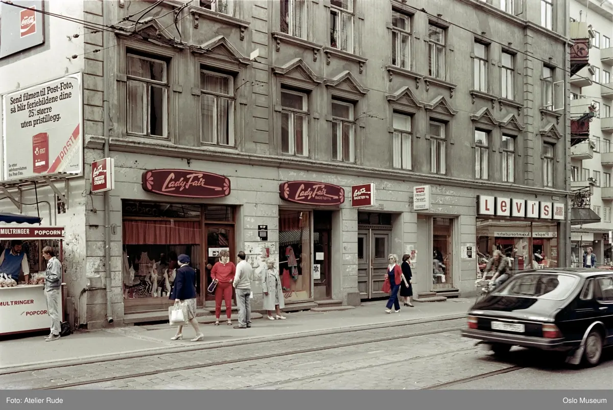 bygård, forretningsgård, Lady Fair badetøyforretning, Levi's jeans-forretning, mennesker, bil, syklist, gateliv, kiosk