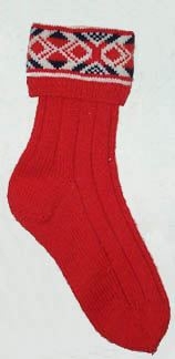 Raggsocka i 4-trådigt rött ullgarn. 1 cm resår sedan blå och röd bjärbobård på vit botten därefter resårstickning 1 r-1a i 3cm sen skaftet 12 cm resår 5 r- 2 a. häl,fot och tå slätstickad