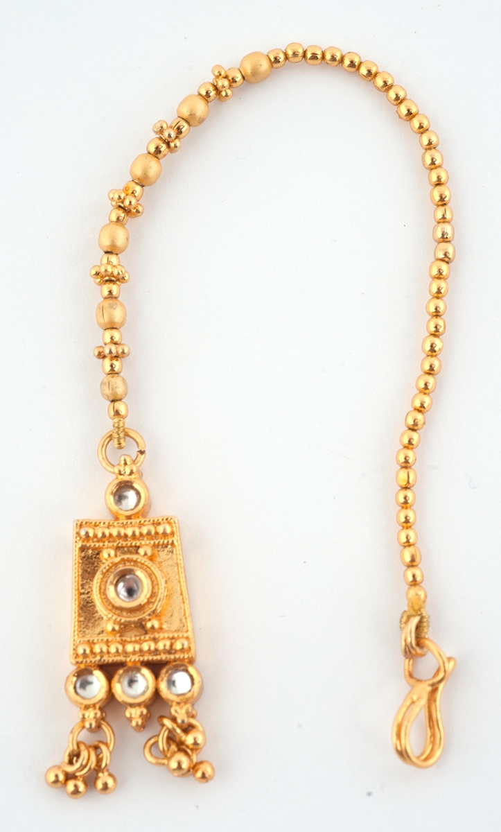 Gullfargede smykker til brudedrakt. Består av 9 armringer, et par øreheng, 2 halssmykker og 2 anheng = ukjent bruk