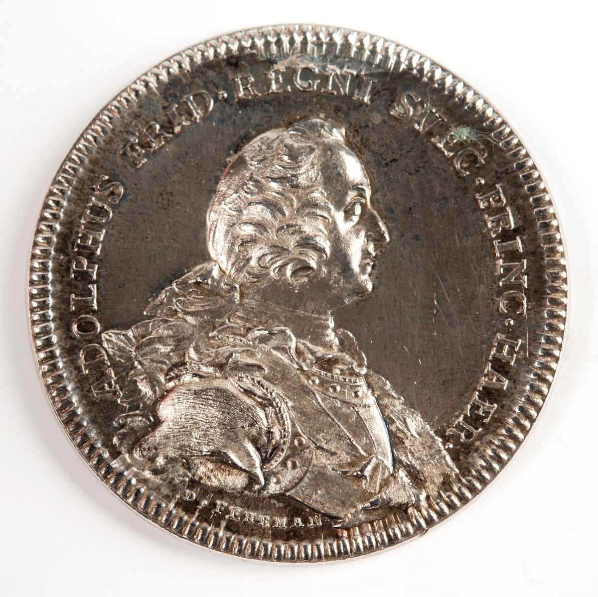 Åtsida: Bröstbild av Adolf Fredrik
Frånsida: en tuktad trädgård med moln.