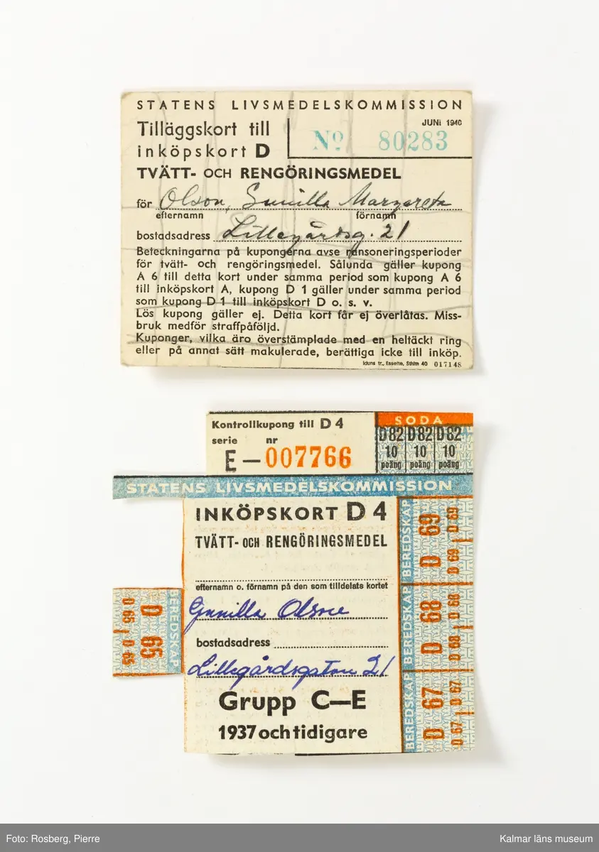 KLM 28613:9 Ransoneringskort i fodral, av papp, ytskikt i läderimitation, brun med grön knapp för knäppning. Indelad i flera avskilda fack för olika typer av ransoneringskort, Växl.-kort Bröd; Växl.-kort Kött; Växl.-kort Matfett; Samlingskort Socker, Bröd, Matfett; Kött; Beredskapskort; Kaffe; Kläder; Tvätt; Ägg. I fodralet ligger omkring 180 kort av alla de slag. Datering, 1940-1945. Tillverkade av Statens livsmedelskommission.
I mappen ligger även ett tidningsurklipp med ransoneringsschema, med villkor för hur inköpskorten fungerade, klippt ur Stockholms-Tidningen, publicerat den 20 juni 1943.