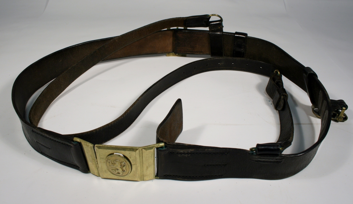 Bandolær i brunt skinn med spenner i messingfarget metall.