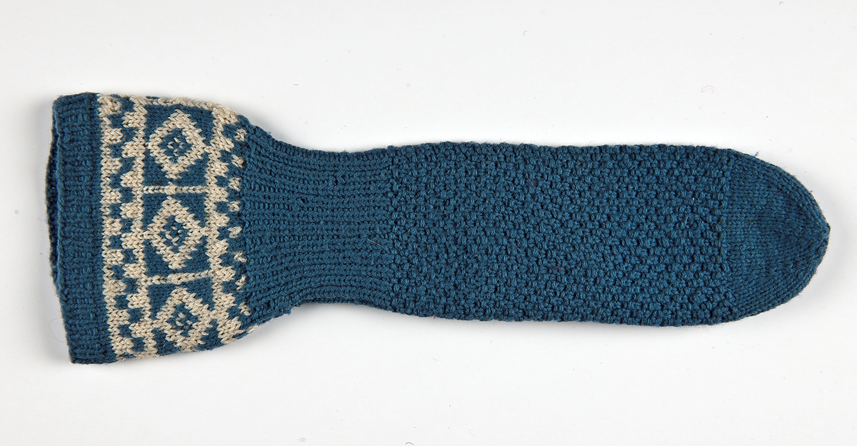 Damkragvante i dubbelt 3-trådigt lj blått ullgarn. 
1cm resår,slätstickad,naturvit och ljusblå blomsterbård,6cm resår ,
handen moss-stickad,tummen och avmaskning,slätstickad