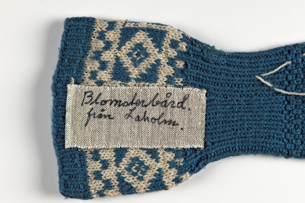 Damkragvante i dubbelt 3-trådigt lj blått ullgarn. 
1cm resår,slätstickad,naturvit och ljusblå blomsterbård,6cm resår ,
handen moss-stickad,tummen och avmaskning,slätstickad