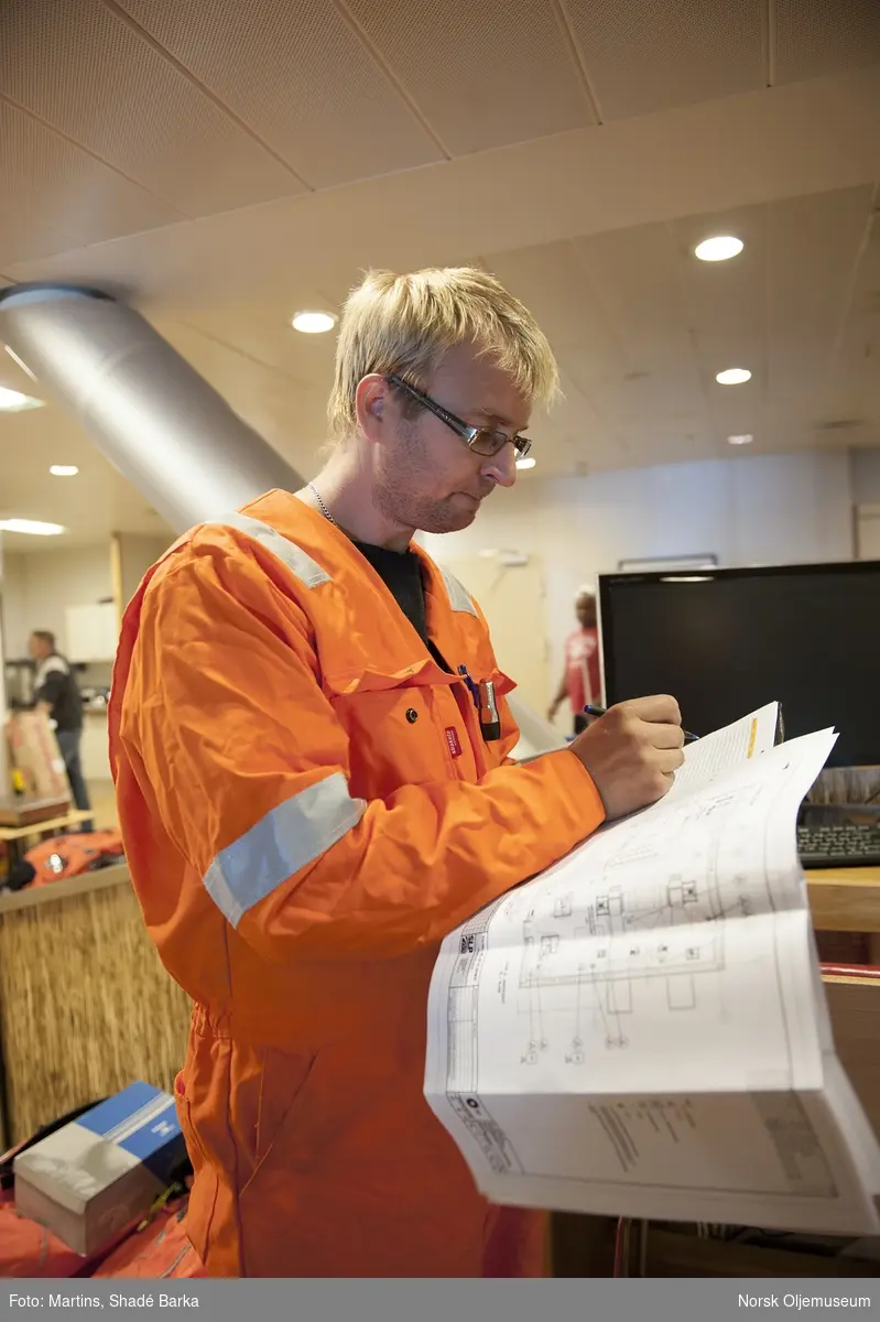Christopher Høvik går rundt med en Norsonic spesialmikrofon og måler ventilasjonsstøy. Endre Åsen noterer dagens funn.