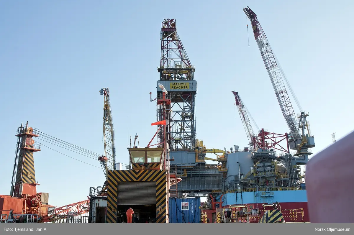 Helikopterdekket på Valhall QP med boreriggen Maersk Reacher i bakgrunnen.  Riggen driver med brønnservice på Valhall DP, og skal plugge brønner over en lengre periode.  Som riggnavnet hentyder, rekker riggen langt innover dekket til Valhall DP og kan på den måten utføre brønnarbeidet. 
Krane samt helikopterhangaren med kontrolltårnet til venstre i bildet.