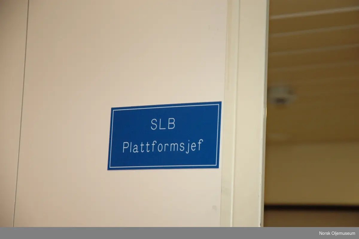 Et blått skilt med påskriften "SLB Plattformsjef" på prosafe sitt flotell "Safe Scandinavia".