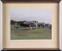 Tre stycken flygplan J 9 från F 8 Svea flygflottilj motorkörs på ett flygfält. Flygtekniker i närheten. Flygplanen är märkta med nummer 33, 70 och 71. Inramat foto. Kolorerat foto.